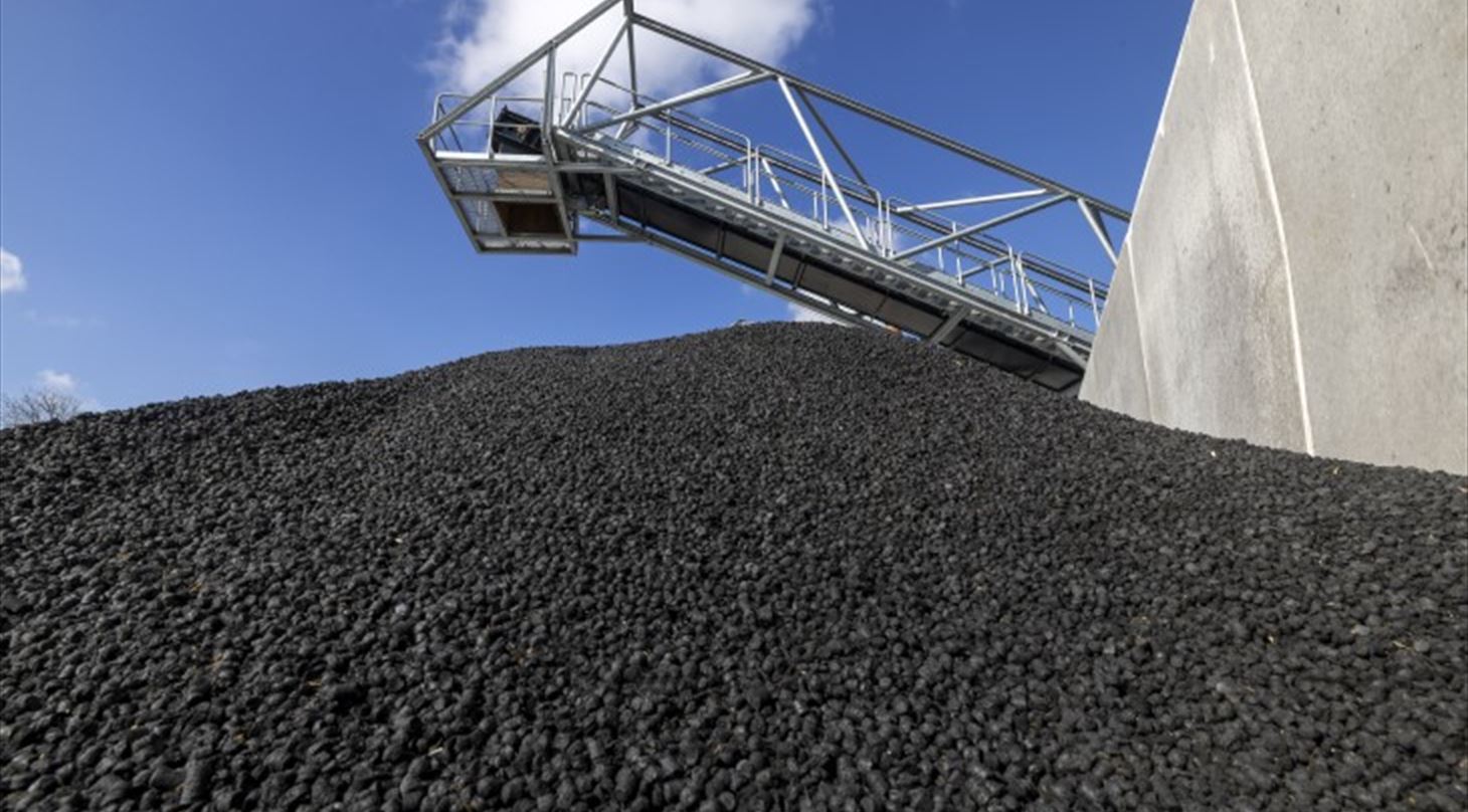 Billedet viser et transportbånd med Biokul, som er et kulstofbaseret materiale